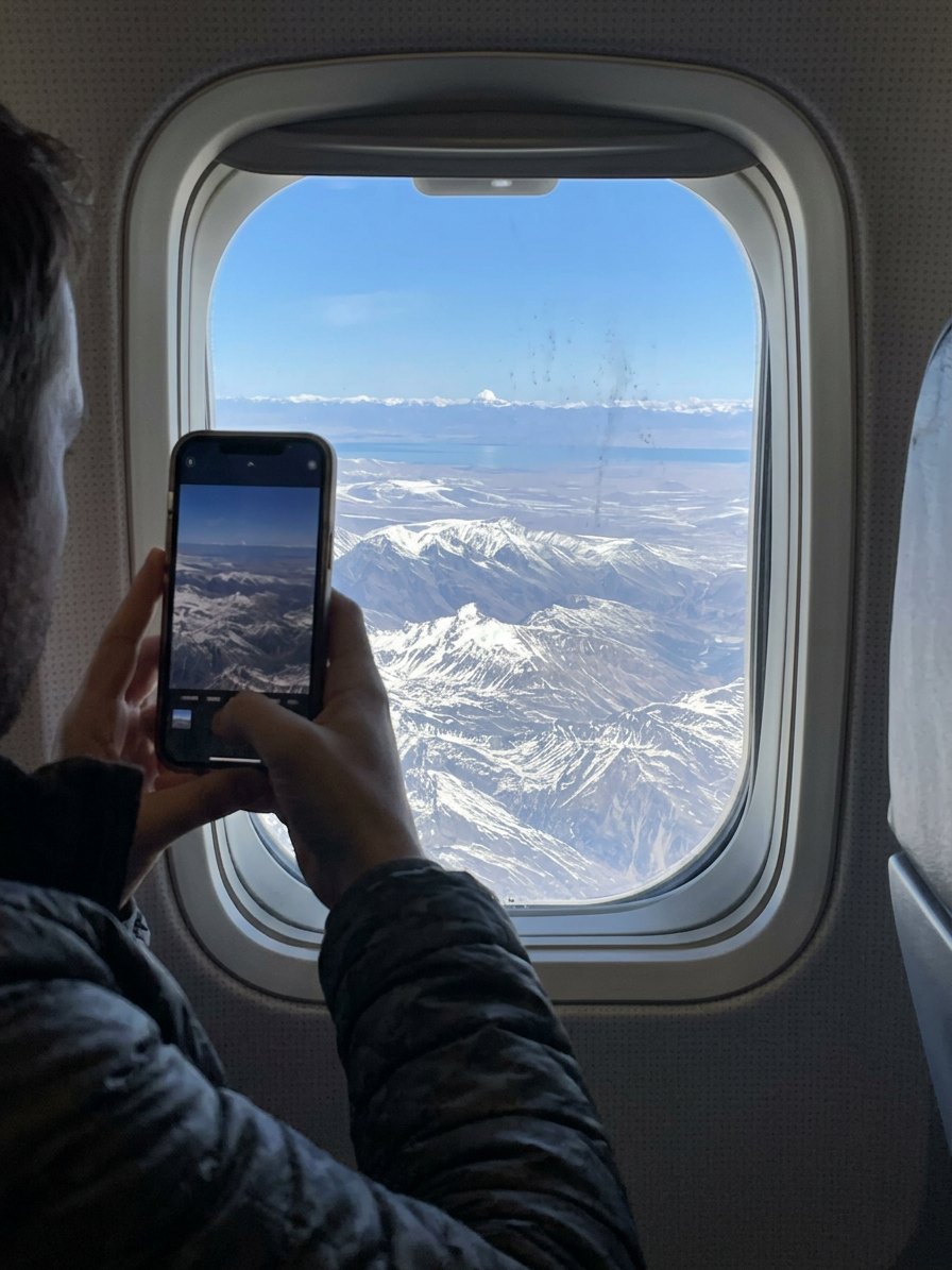 Guest taking picture of Kailash Mansarovar from plane during aerial flight